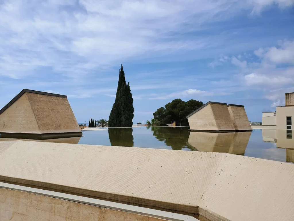 Cubiertas piramidales del edificio Moneo de la Fundació Miró Mallorca sobre un espejo de agua