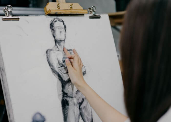 Estudiante de Bellas Artes dibujando con carboncillo en un taller universitario