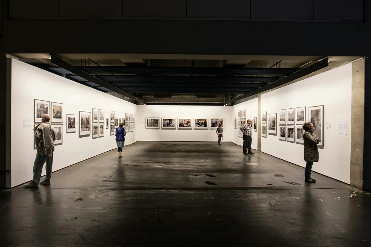 Visitantes ante cuadros en una feria de arte contemporáneo como Estampa 2026 – Totenart