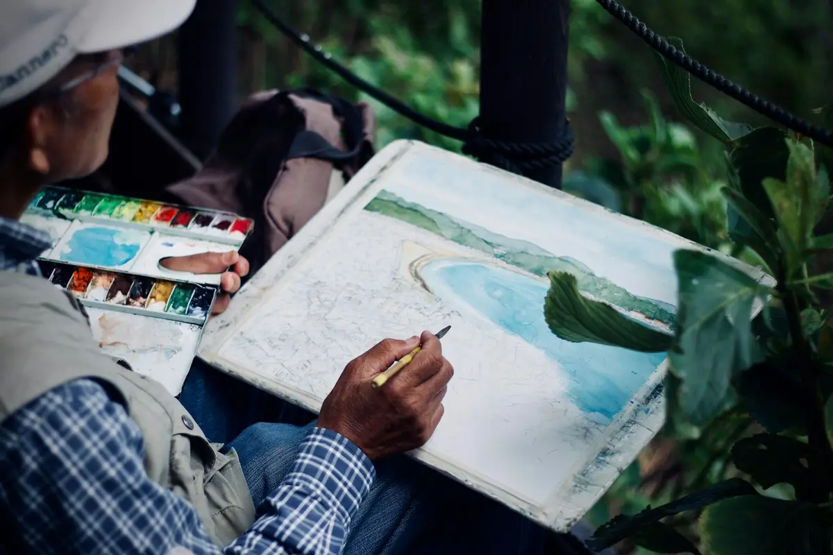 Acuarelas fáciles: 10 ideas para empezar a pintar 8 Persona pintando un paisaje de costa con acuarelas al aire libre – Totenart