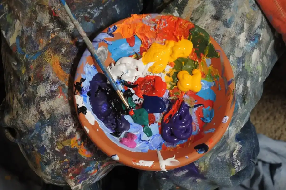 Paleta de barro con pinturas de colores, entre ellas azul, amarillo y un poco de verde, cómo hacer color verde – totenart